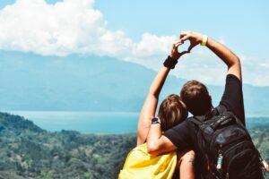 couple hugging and making a heart with their hands and looking out over a landscape 9 new years relationship resolutions dating safety tips